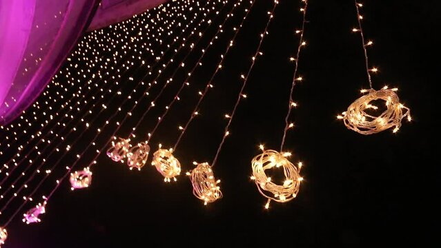 Vintage bulb and party lights in a backyard on venue, Outdoor string lights hanging on a line on outside house in backyard, Garden decoration,  Party camping.
