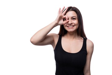 Fototapeta premium Casual pretty young brunette woman wearing a black t-shirt on a white background