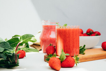 Fruit smoothie in transparent cups. Red strawberry smoothie on a concrete background. The concept of healthy eating. Front view