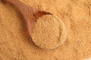 Brown coconut sugar and spoon, top view