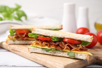 Delicious sandwiches with fried bacon on wooden rustic table, closeup