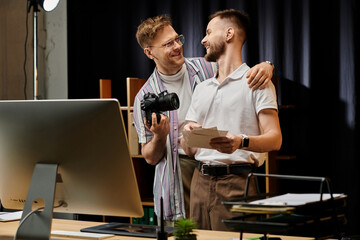 Two men collaborate on computer projects in modern office setting.