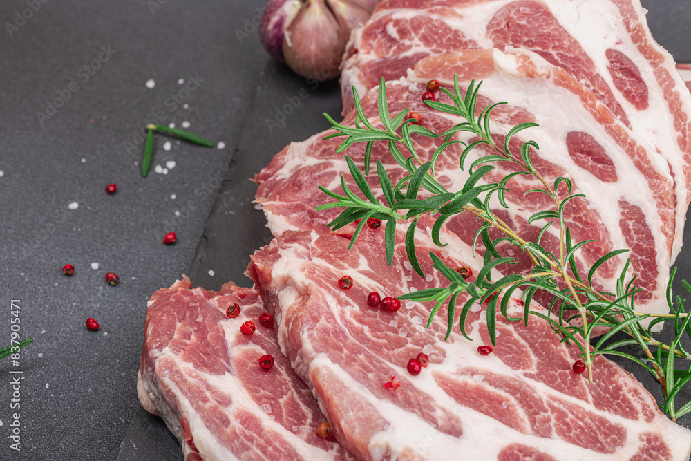 Wall mural raw pork neck meat. chop steak, red peppercorn, garlic cloves, sea salt and fresh rosemary