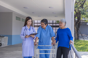 doctor or nurse helping Senior man to walk at nursing home with walker. Doctor or  nurse helping old elderly disable man grandfather to walk using walker equipment