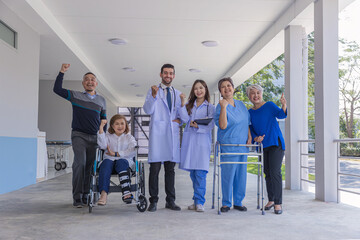 Fototapeta premium Doctors and nurse in hospital corridor with senior female and senior male patient in walker and wheel chair
