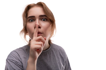 Teenage girl begs and looks at the camera on a white background with copy space