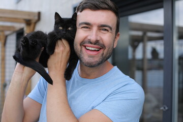 Obraz premium Handsome man with a very cute black baby cat 