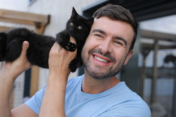 Handsome man with a very cute black baby cat 