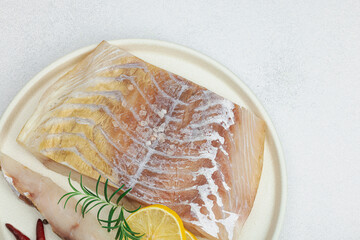 Raw pollock (Pollachius virens) fillet. Fresh fish for healthy food lifestyle. Spices and herbs
