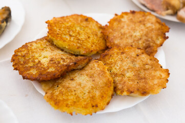 Potato pancakes with sour cream on white plate