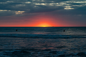 Sunrise in the Ocean with Surfers