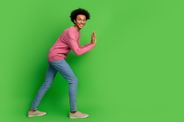 Full length photo of funky cool guy dressed pink pullover pushing emtpy space isolated green color...