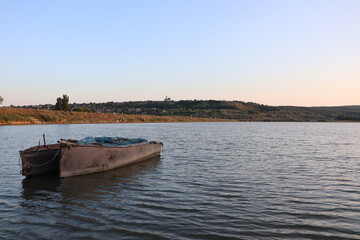 A boat peacefully floats on water under the open sky, creating serene landscape