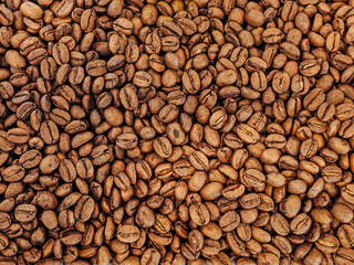 Real brown whole bean coffee texture pattern background come form organic farm and already roast for cafe coffee shop use