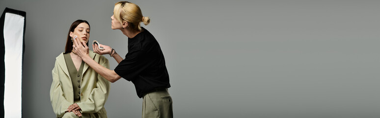 Stylish lgbtq makeup artist stands near his client.