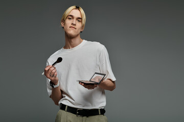 Elegant man multitasking with a palette of makeup.