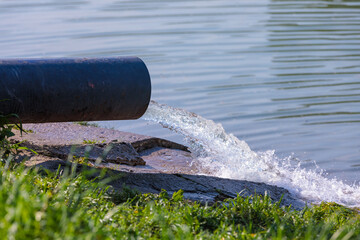 The pipe discharges water into a natural reservoir