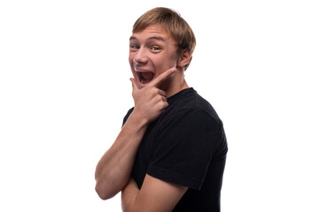 Cheerful blond teenager young man smiling against a background with copyspace