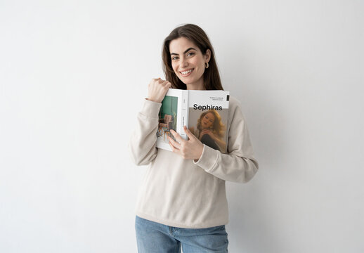 Mockup of woman holding customizable book, smiling