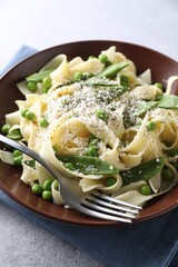 Delicious pasta with green peas and cheese served on grey table