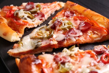 Pieces of delicious pizza Diablo on textured board, closeup