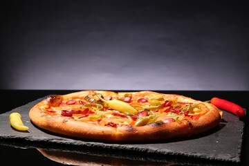 Delicious pizza Diablo on slate board against grey background