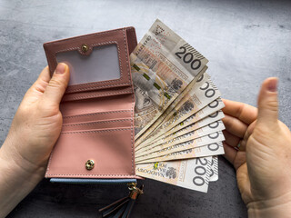 close up woman pulls out polish zloty money from wallet. Polish economy