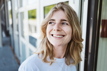 Portrait of a cheerful woman with a nose ring smiling while enjoying a sunny day outdoors. Bright and happy mood.