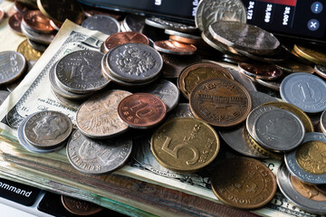 Pile of various coins on the stack of various banknotes