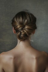 A woman with a bun in her hair. The bun is pulled back and is in the middle of her head
