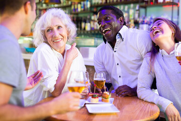 Happy friends drinking beer and chatting with each other in a restaurant