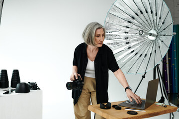A woman stands engaged in front of a laptop, collaborating on a project in a tech-forward workspace.