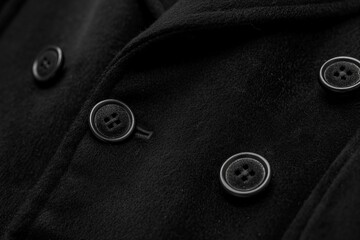 A close-up view of the buttons on a black tuxedo jacket.