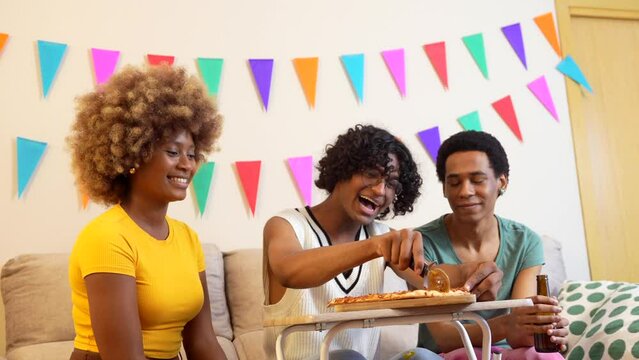 Multi-ethnic friends sharing homemade pizza during a party at home
