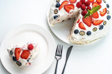 Pavlov dessert with strawberries, blueberries, raspberries, mascarpone cream. Light meringue dessert. Light background