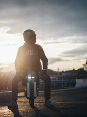 A man wearing a helmet is sitting on an euc monowheel. Electric urban transport © pavelkant