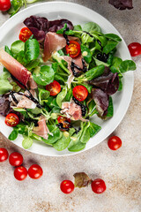 jamon salad green leaf lettuce, tomato, salad dressing appetizer meal food snack on the table copy space food background rustic top view keto or paleo diet