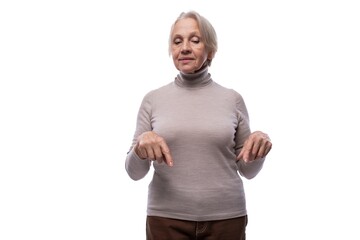 Granny with gray hair shows finger down on white background