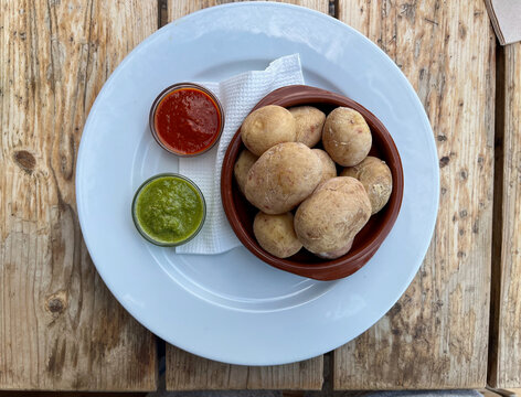 Canary Islands dish Papas Arrugadas wrinkly salty potatoes with and Mojo picon red spicy sauce.