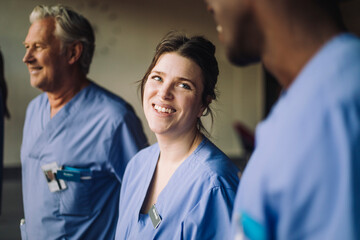 Smiling female doctor with multiracial colleagues in hospital