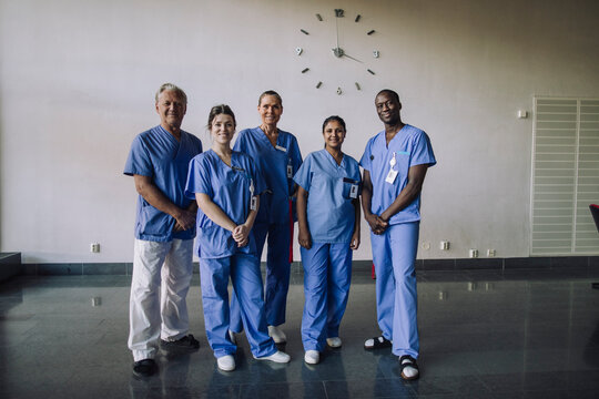 Full length portrait of confident diverse healthcare professionals standing together in hospital