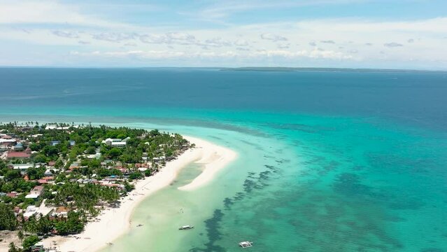 Aerial view of sandy beach with palm trees and sea surf with waves. Bantayan island, Philippines.