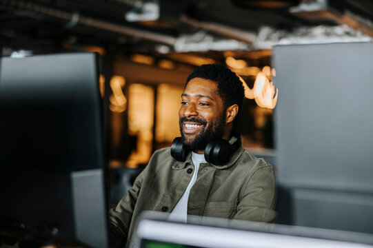 Smiling male entrepreneur working at tech start up office