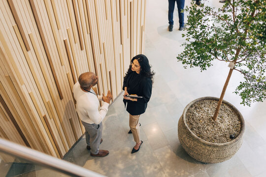 High angle view of male and female business professionals discussing together during networking event at convention cent