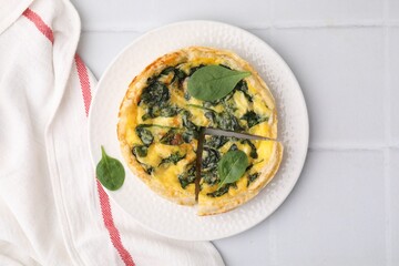 Delicious pie with spinach on white tiled table, top view