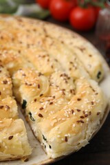 Delicious puff pastry with spinach on table, closeup
