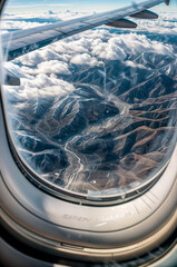 Obraz premium View from an airplane window to a mountain and a rock. Flying on an airplane. Organizing your holiday travel