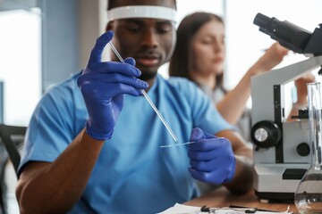 Using test tubes. Group of doctors are together indoors