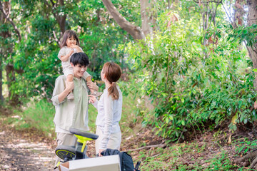 森の中でアウトドアカートを使う家族