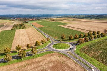 Bird's eye view of a roundabout surrounded by fields and meadows